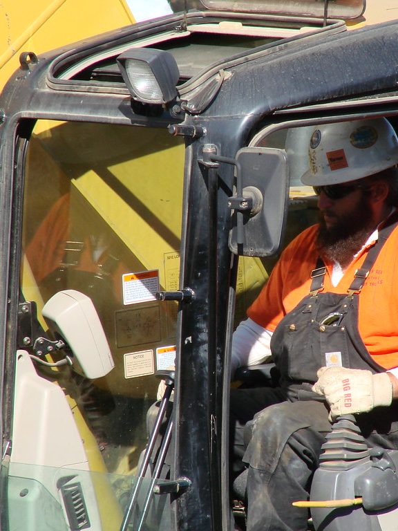 Compagnon aux commandes d'une mini-pelle sur un chantier de démolition