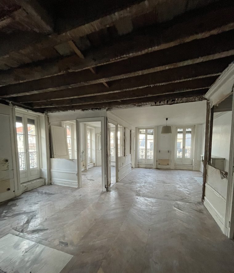 Curage d'un appartement ancien à Lyon : parquet protégé, poutres apparentes après dépose des plafonds